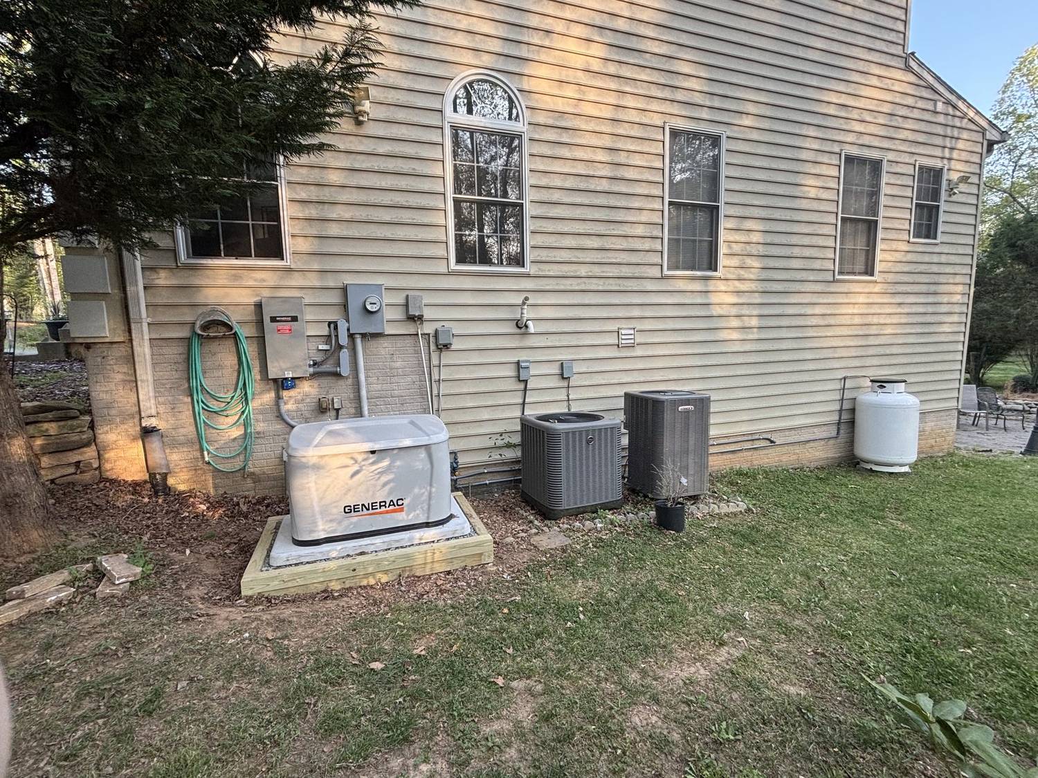 Standby generator installed beside a home, next to the air conditioning units