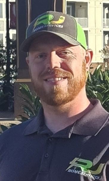 Jake, co-owner of RJ Home Services, in an RJ cap