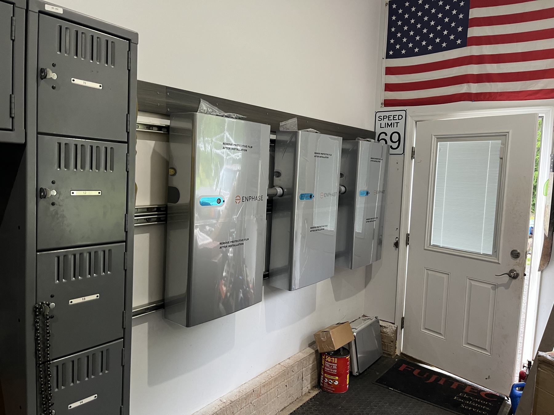 Electrical panels installed on a garage wall below an American flag