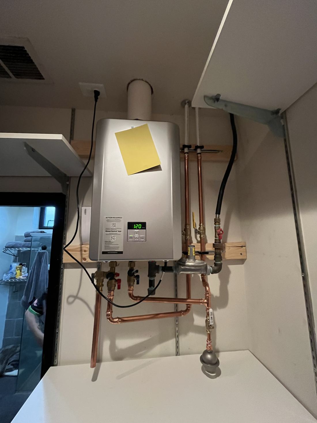 Tankless water heater mounted on a wall with new copper piping
