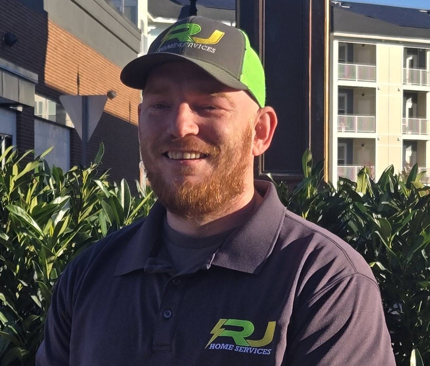Tommy, an RJ Home Services tech, smiling in an RJ cap
